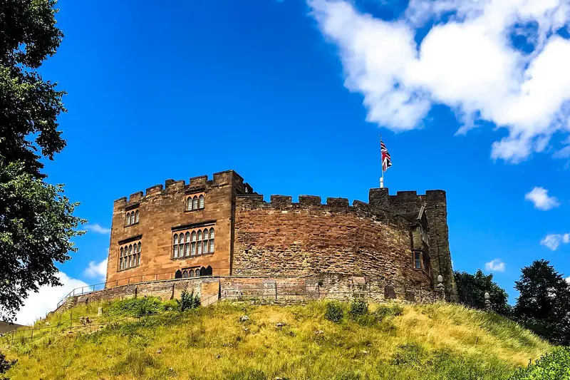 Tamworth Castle on its grassy mound beneath a bright blue sky